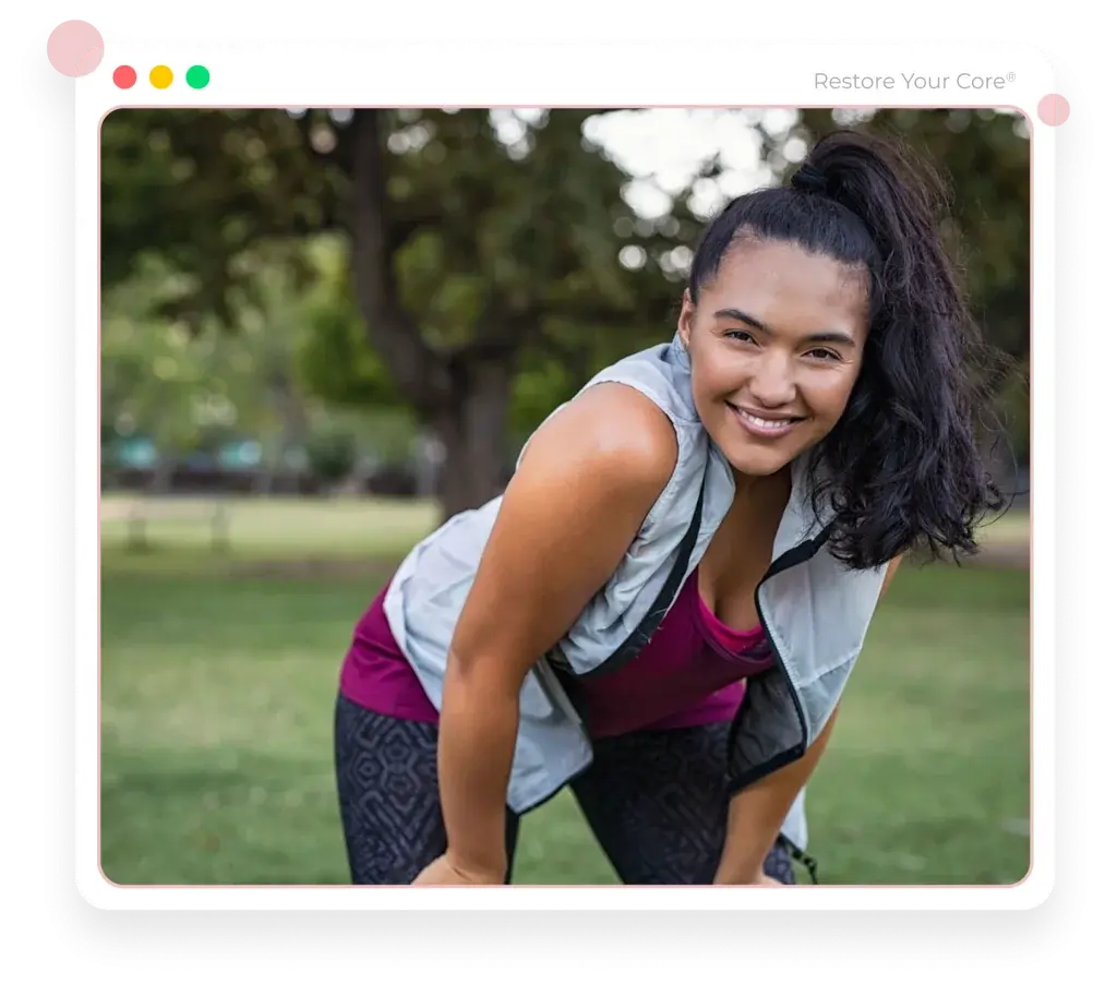 A smiling woman resting her hands on her knees after a workout in the park